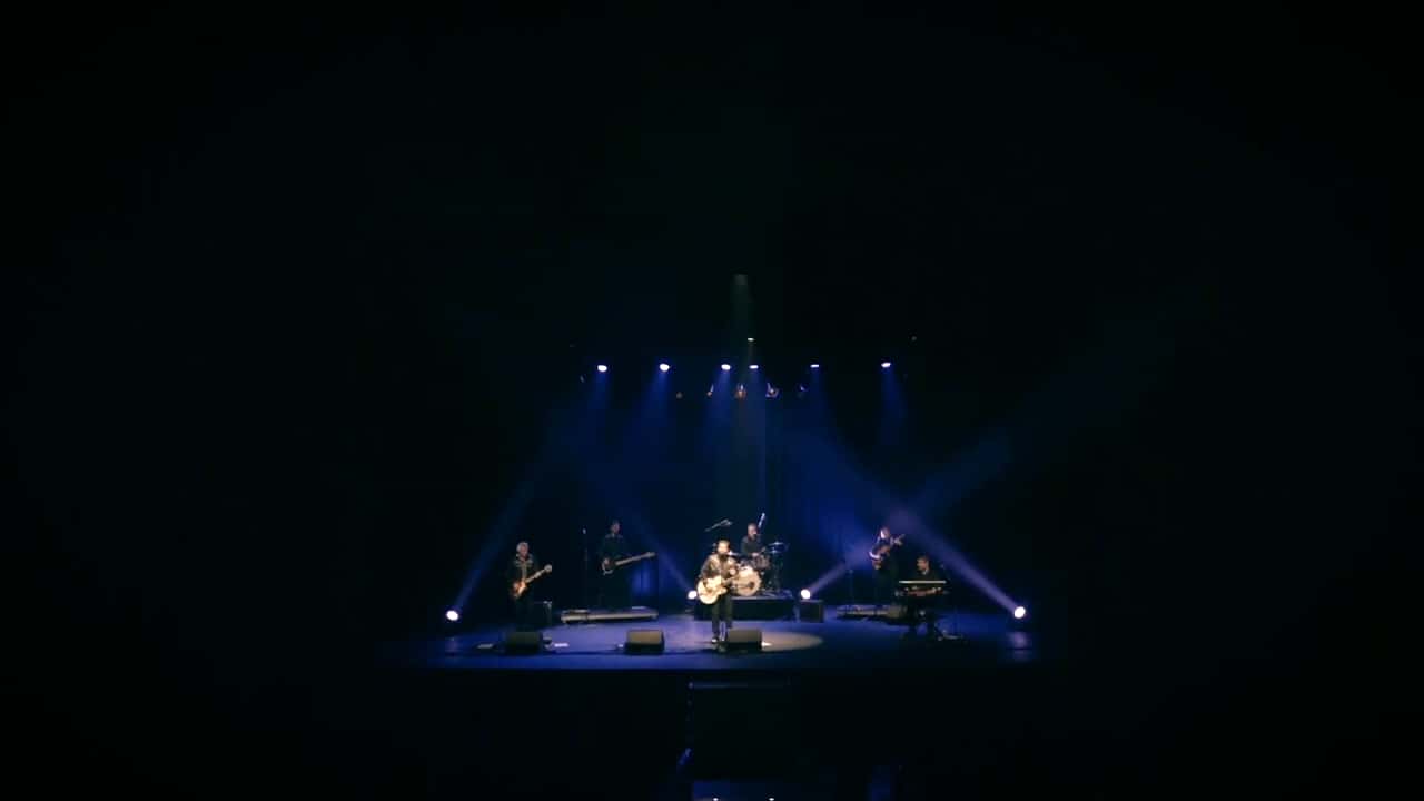 El Teatro Auditorio de Roquetas de Mar a oscuras, con el escenario iluminado durante un concierto de JJ Fuentes